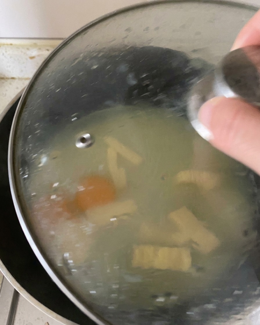 Un coperchio di vetro posizionato sulla padella per trattenere il vapore, cuocere le uova e sciogliere il formaggio.