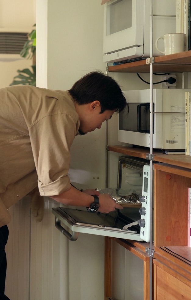 Una teglia con le costine avvolte nellalluminio inserita nel forno preriscaldato.