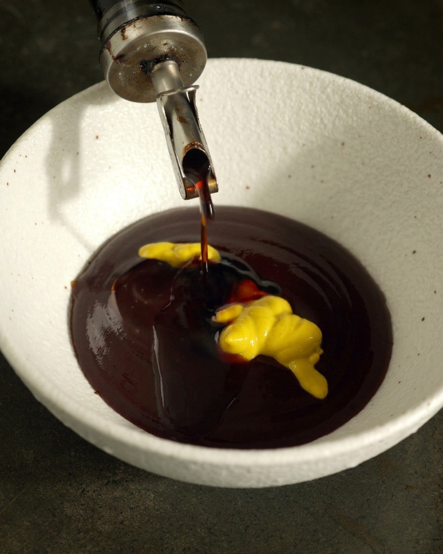Salsa di soia versata in una ciotola con salsa BBQ e senape gialla.