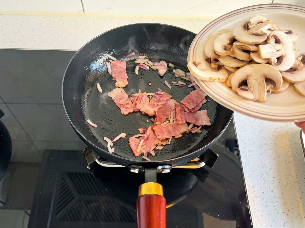 Funghi champignon affettati che scivolano da un piatto in padella con cipolla e pancetta.
