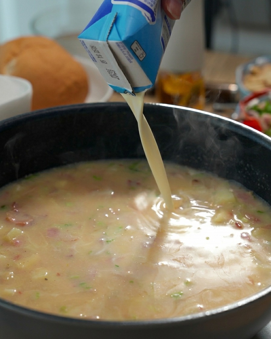 Panna fresca versata nella padella con la base della zuppa che sobbolle.