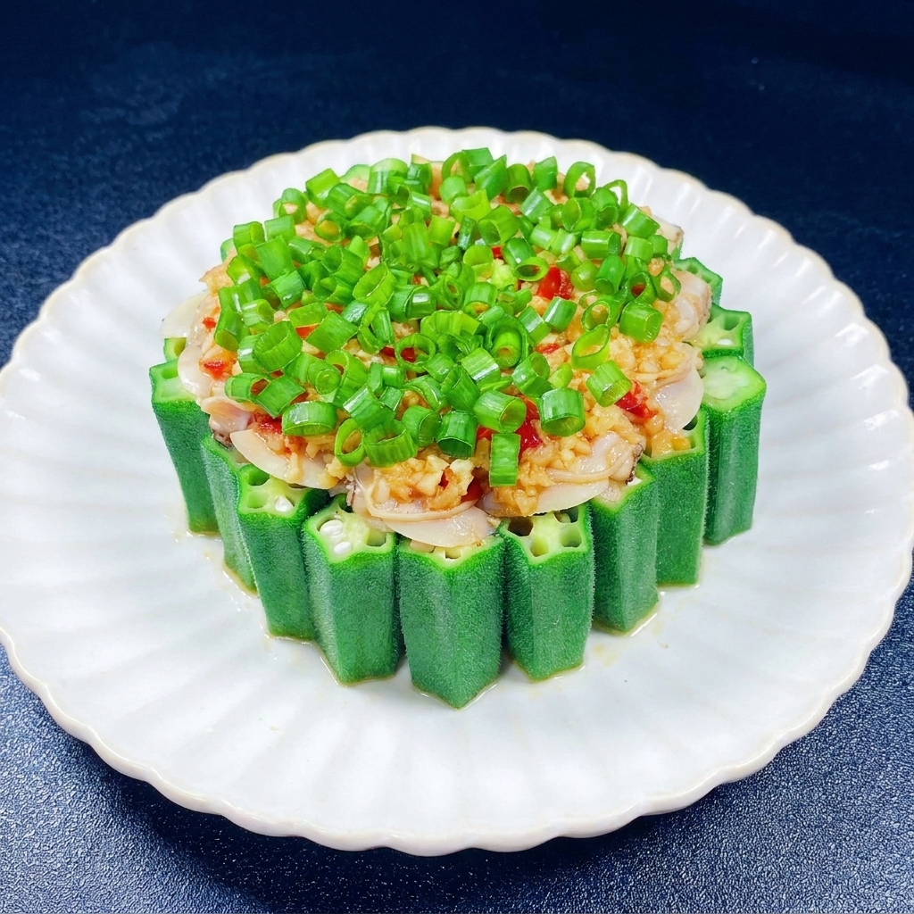 Una manciata di cipollotti verdi tritati sopra laglio e la polpa di vongole allinterno dellanello di okra.