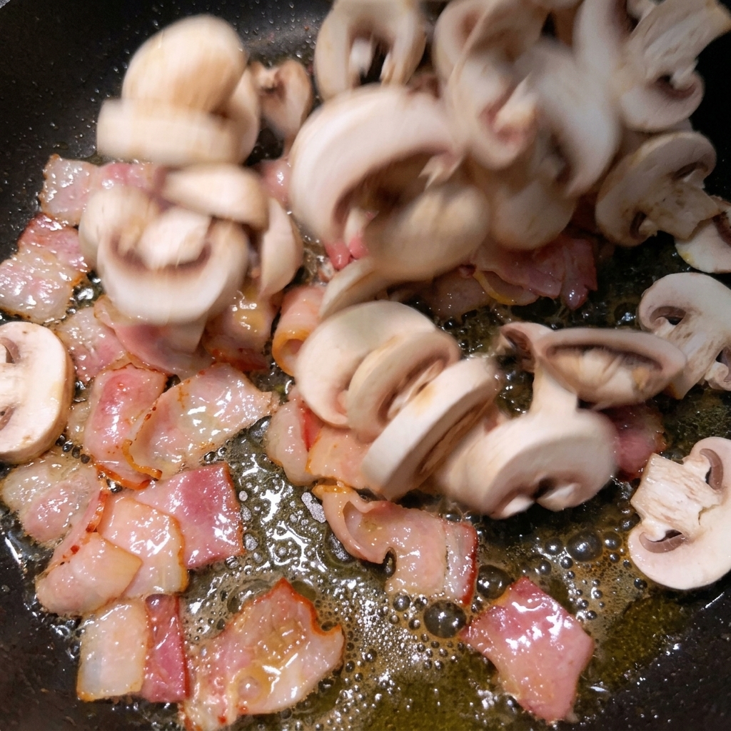 Funghi champignon affettati aggiunti in padella con la pancetta croccante.