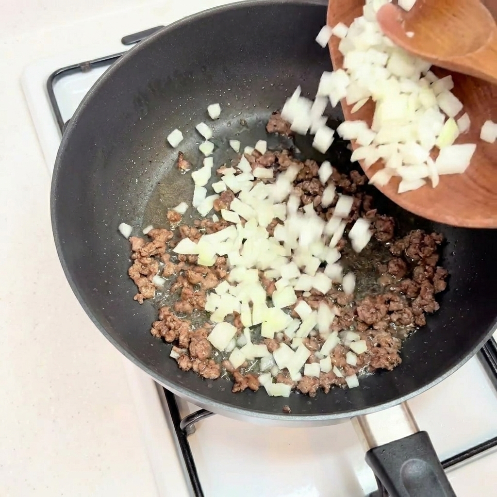 Cipolla bianca tritata aggiunta al macinato di manzo ben rosolato.