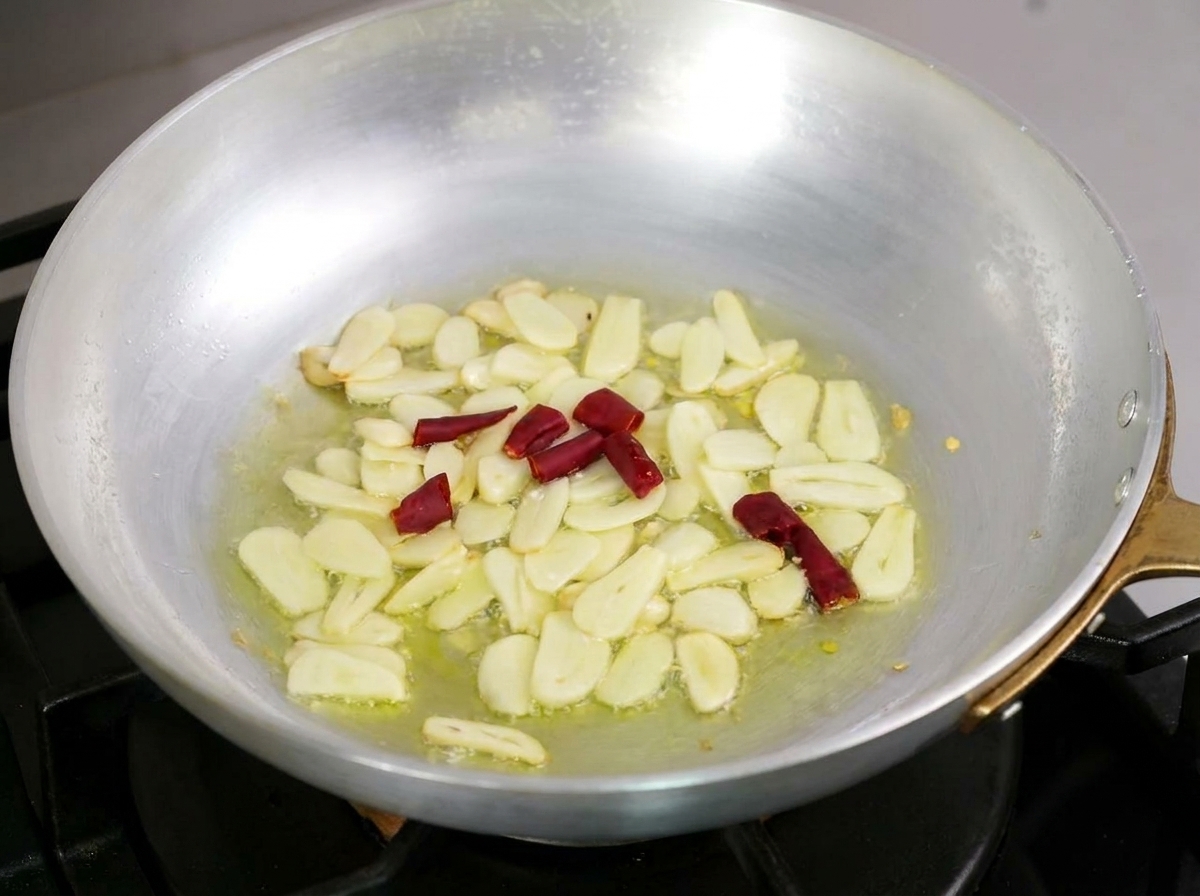 Aglio affettato e peperoncino rosso che sfrigolano delicatamente nellolio doliva.