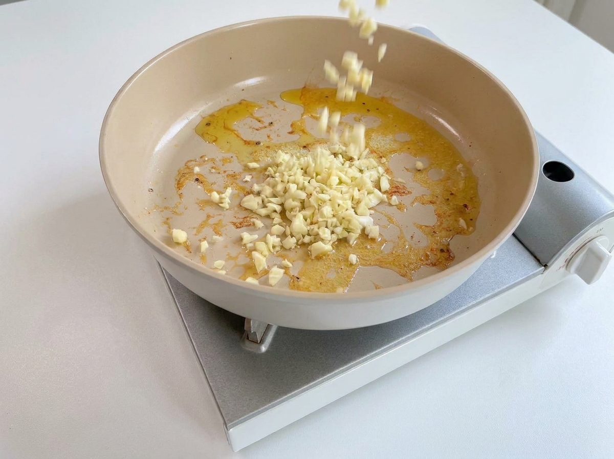 Aglio tritato aggiunto in padella con i residui di olio e burro saporito.