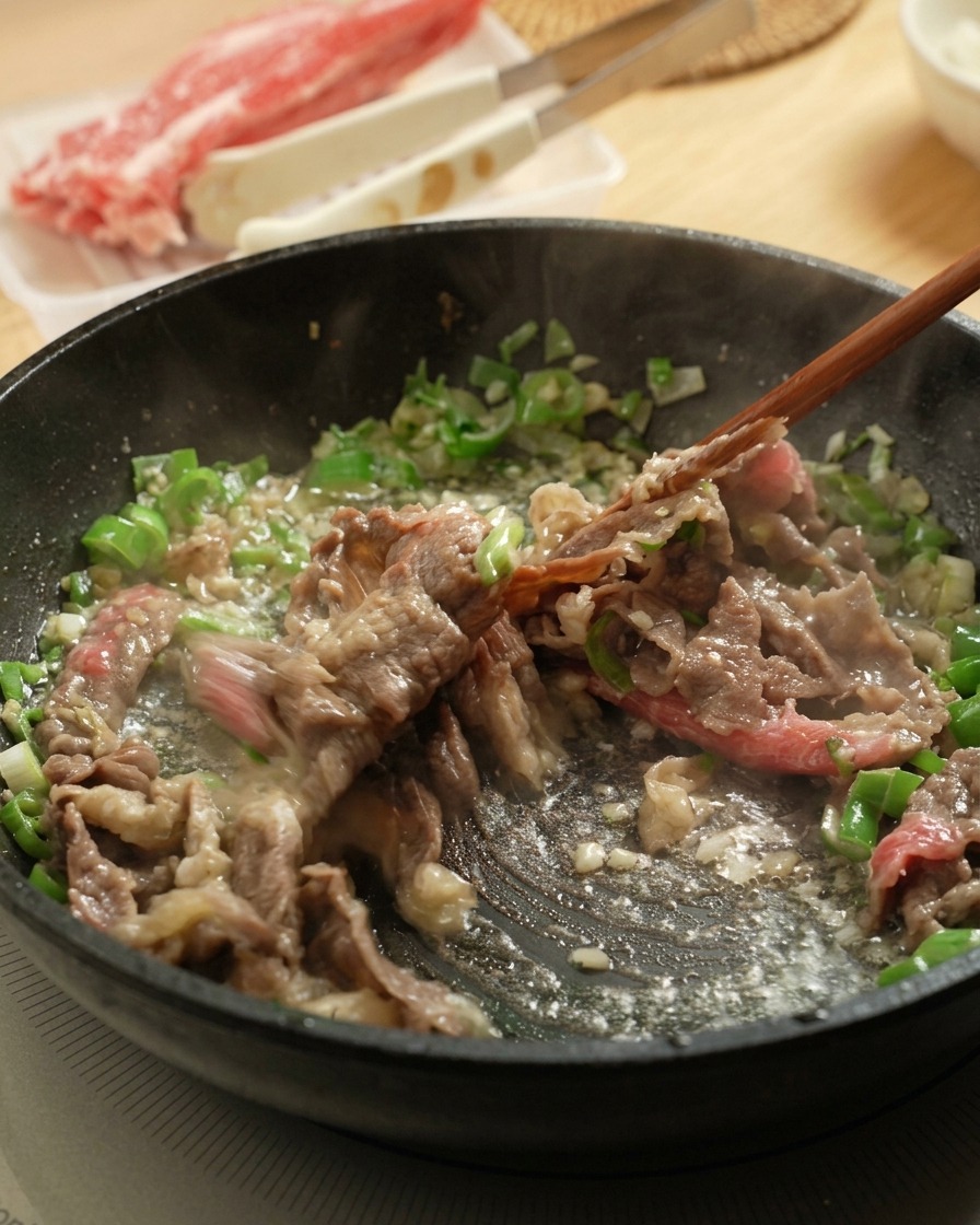 Usare le bacchette per saltare il manzo in padella con aromi.