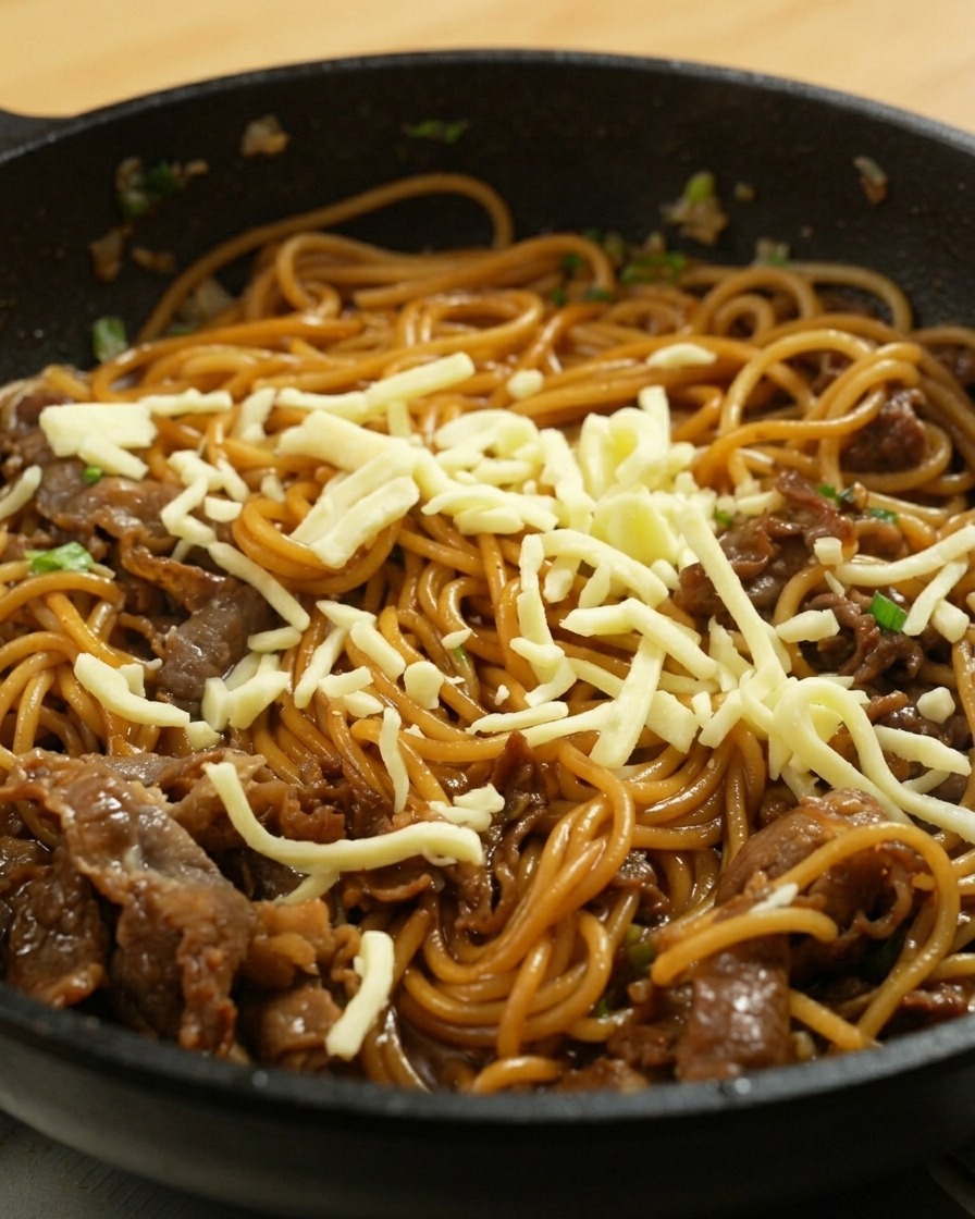 Dettaglio della mozzarella sopra gli spaghetti in padella.