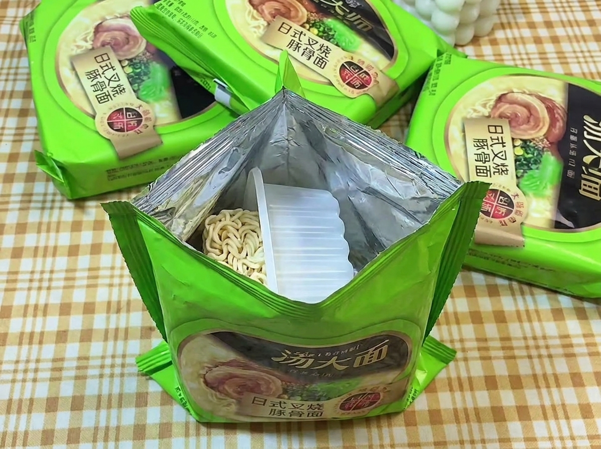 Una confezione aperta di ramen istantaneo che mostra il blocco di noodles secchi e ondulati.