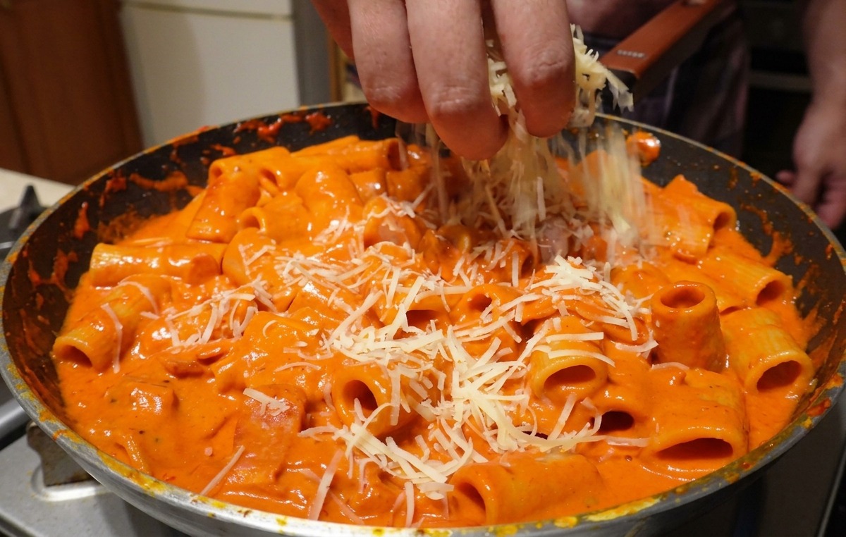 Parmigiano grattugiato spolverato generosamente su rigatoni conditi con salsa alla vodka rosa.