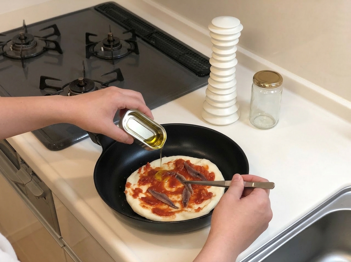 Uso di pinzette per disporre filetti di acciughe sulla salsa mentre si versa un filo dolio dalla scatoletta.
