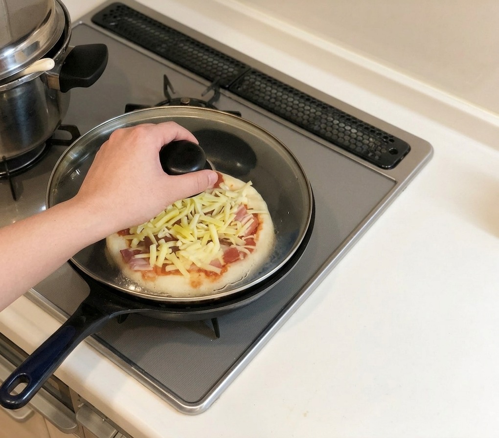 Una mano mette un coperchio di vetro sulla padella con la pizza sul fornello a gas.