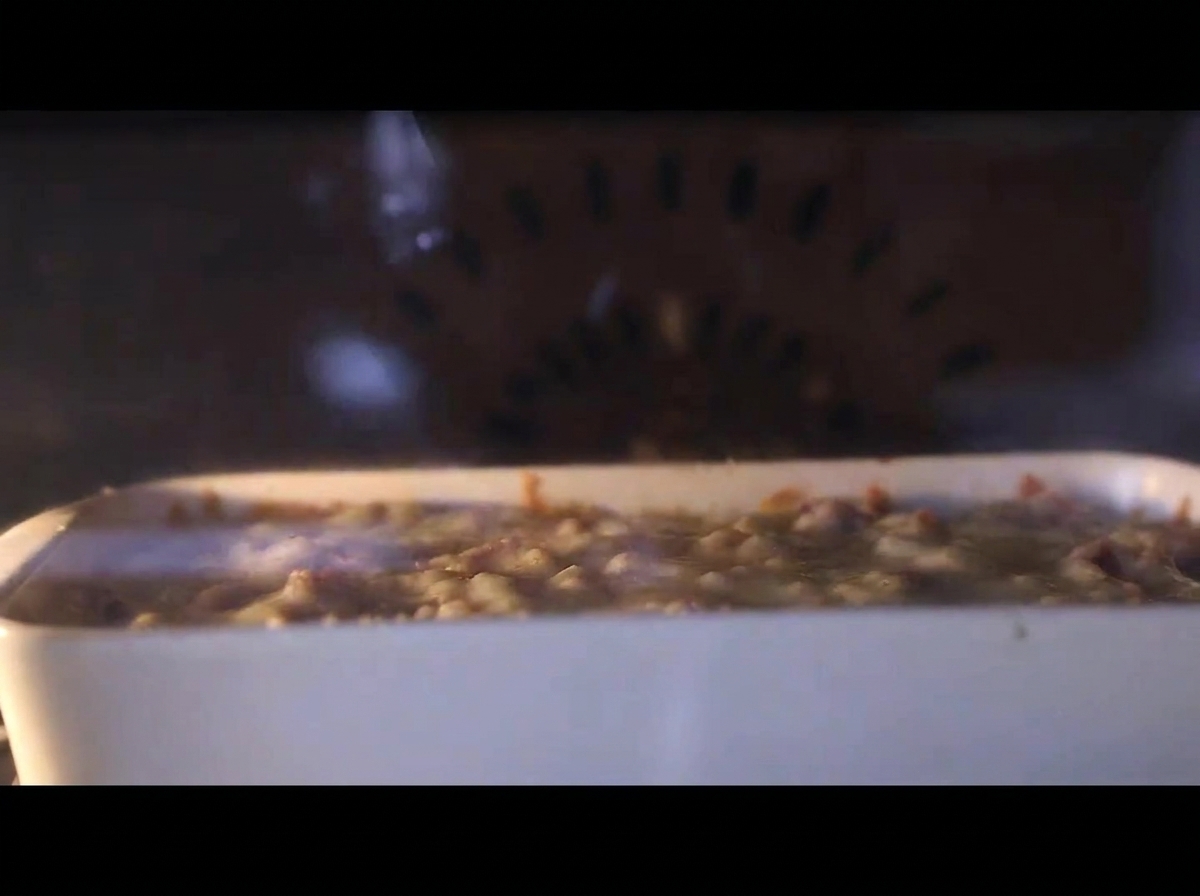 Dettaglio della teglia in forno con il formaggio che ribolle e diventa dorato.