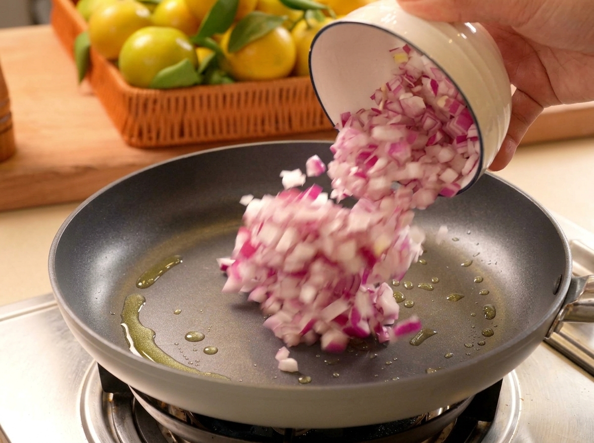 Cipolle rosse tritate versate da una ciotolina in una padella calda con olio.