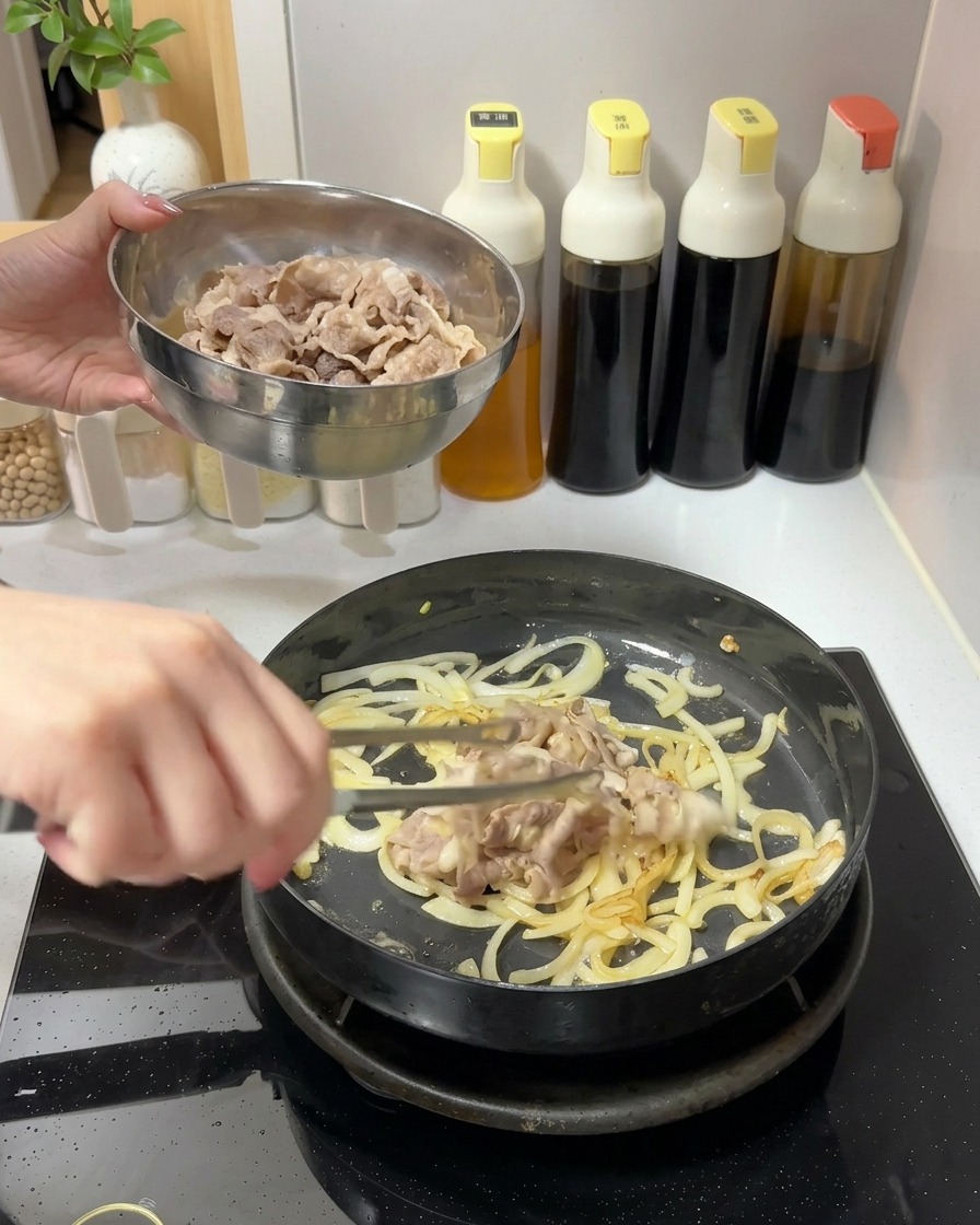 Aggiunta di una ciotola di fettine di manzo cotte in una padella con cipolle saltate.