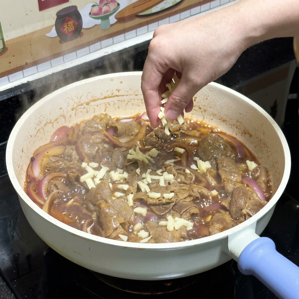 Una mano che sparge mozzarella bianca grattugiata sopra il manzo teriyaki cotto e le cipolle rosse in una padella.