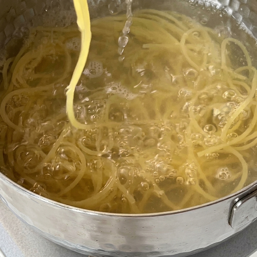 Spaghetti che vengono scolati in un colino nel lavandino della cucina.