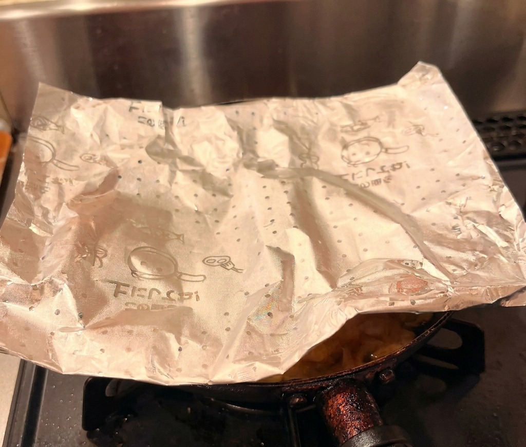 Il condimento di pollo e uova pronto che viene fatto scivolare delicatamente dalla padella su una ciotola di riso bianco.