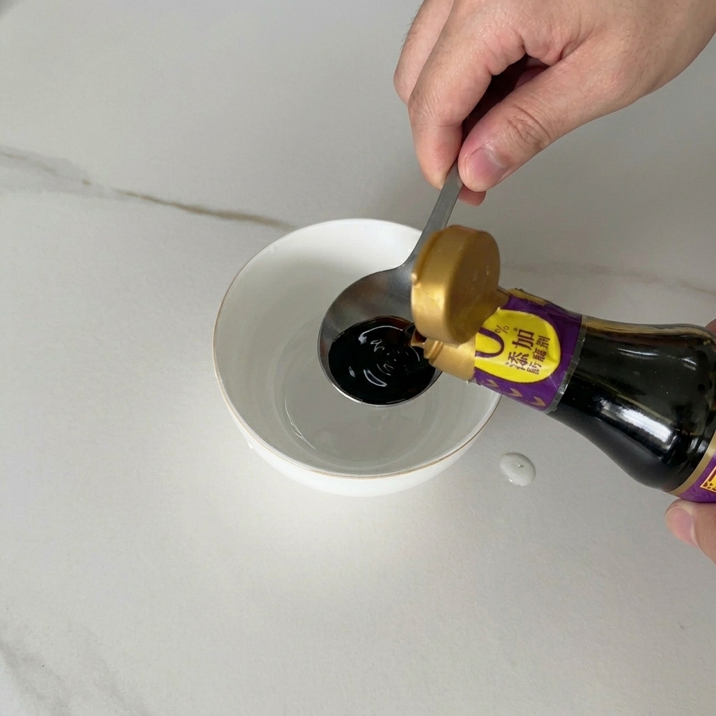 Salsa di soia scura versata da una bottiglia in una piccola ciotola di ceramica bianca contenente altri ingredienti liquidi.