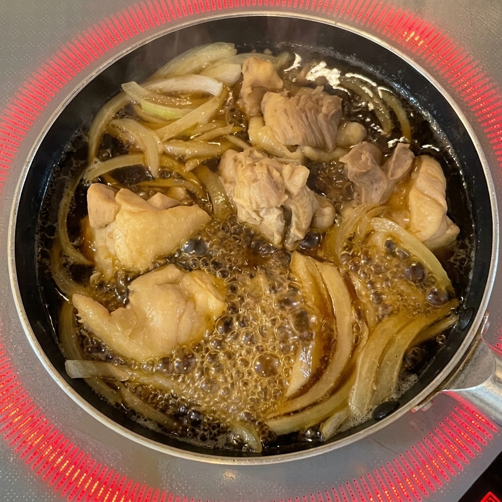 Uovo sbattuto versato da una ciotola nella padella sopra il pollo e le cipolle.