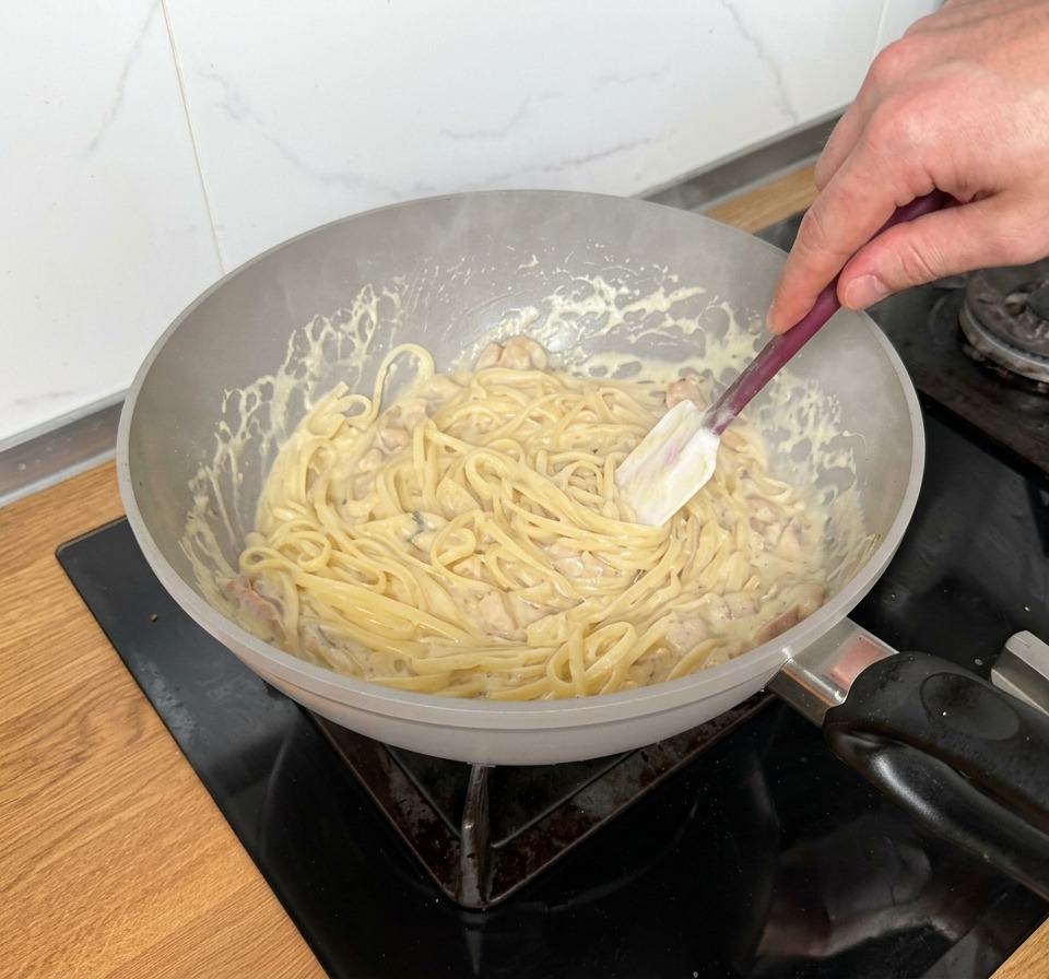 Linguine saltate in padella con una crema ricca, strisce di pancetta e funghi.