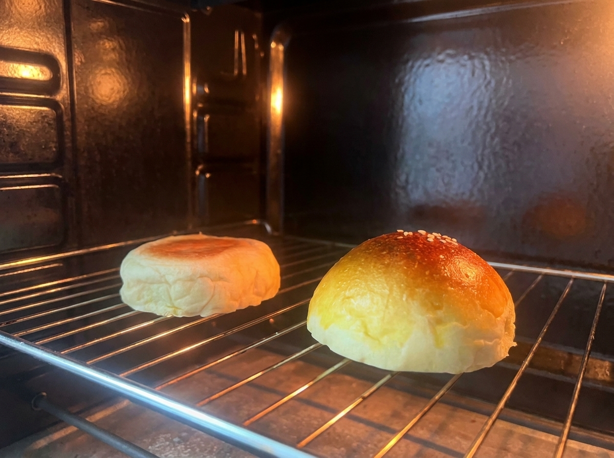 Due metà di un panino da burger che tostano su una griglia allinterno di un forno.