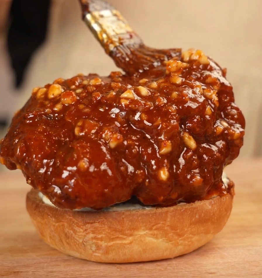 Pollo glassato sulla base del panino spennellato con extra salsa piccante.