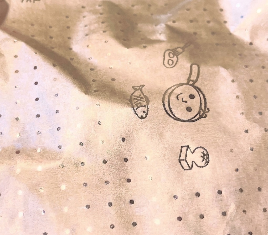 Un primo piano di un coperchio circolare in carta da forno con motivi geometrici che copre una padella durante la cottura a vapore.