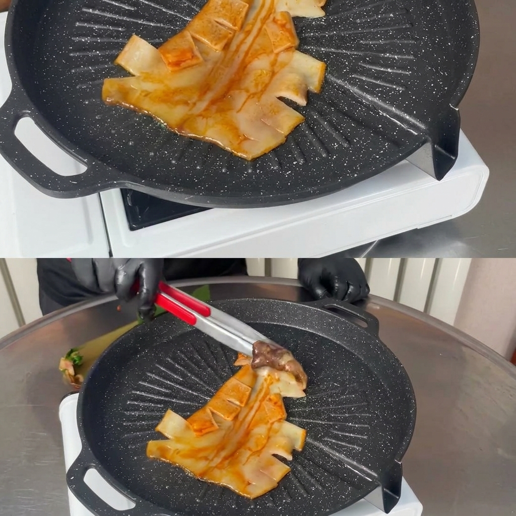 Pinze di metallo adagiano un calamaro intero marinato su una piastra grill nera bollente e rigata.