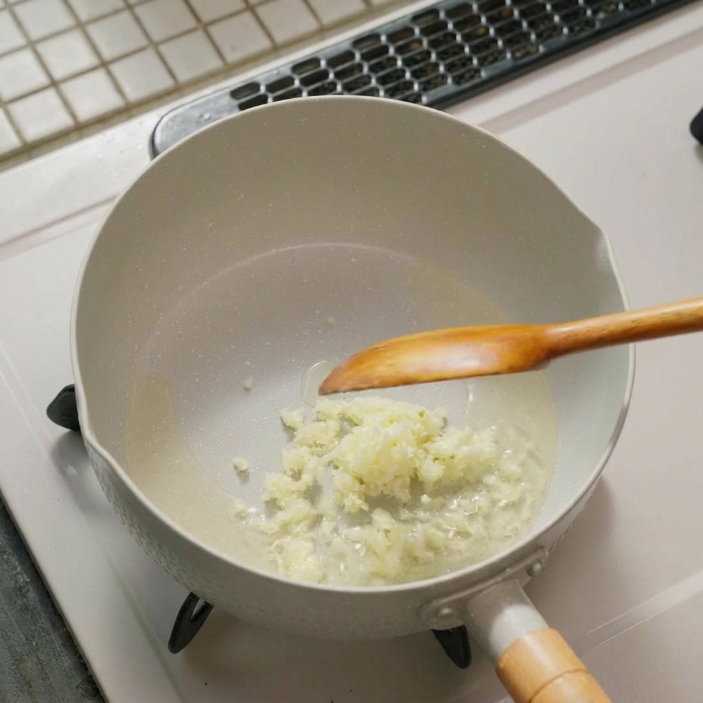 Aglio e cipollotto che sfrigolano in padella.