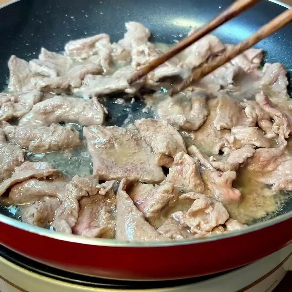 Strisce di manzo marinate che vengono saltate velocemente in padella finché non cambiano colore.