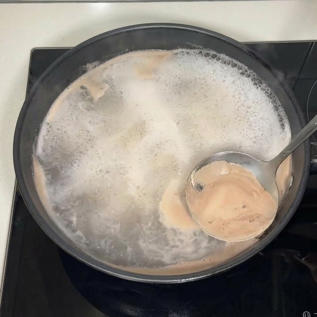 Una schiumarola rimuove la schiuma dalla superficie del brodo.