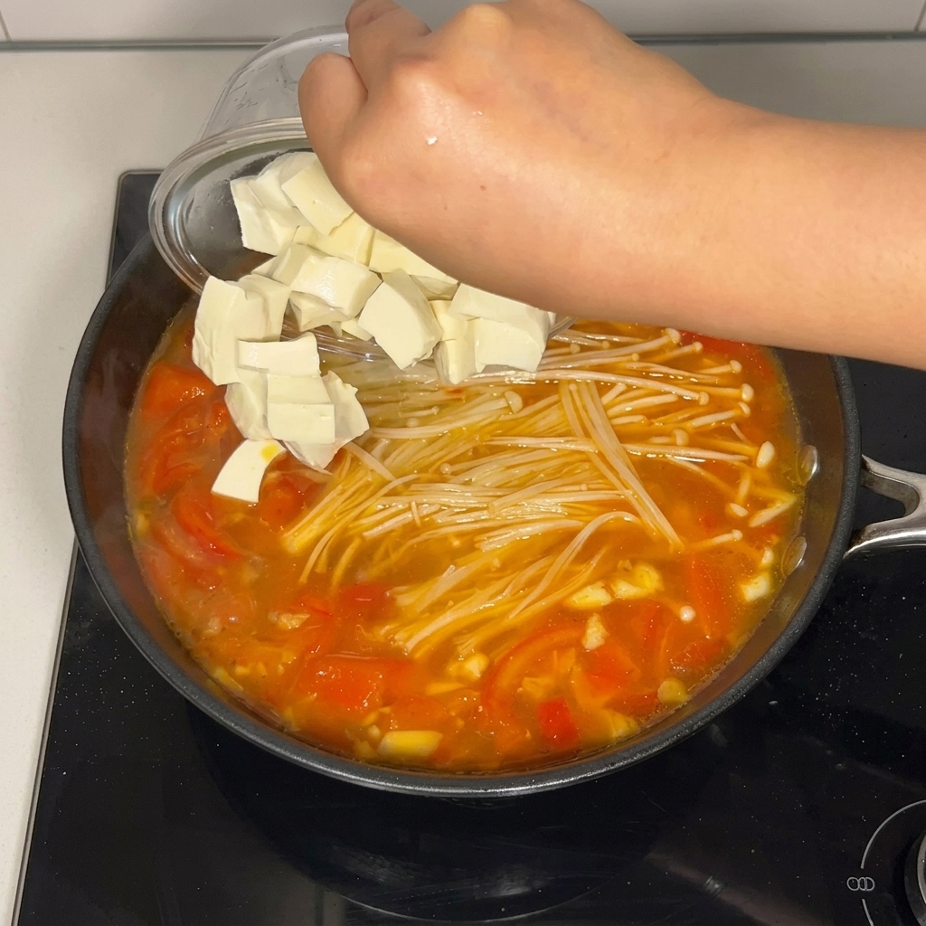 Cubetti di tofu morbido versati nella zuppa.