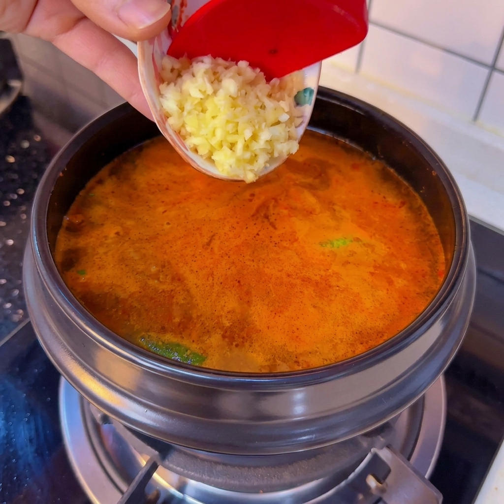 Aglio tritato aggiunto alla zuppa bollente di tofu.
