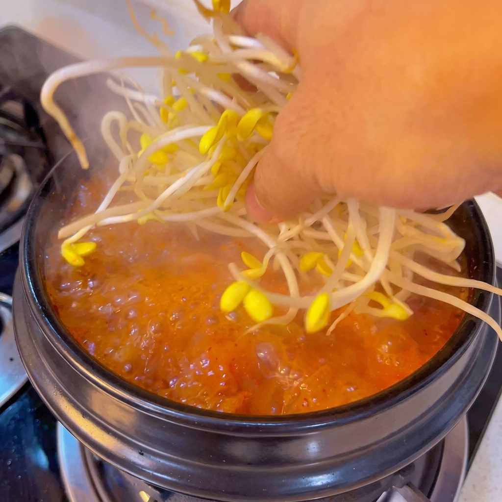 Germogli di soia fresca aggiunti nella zuppa in ebollizione.