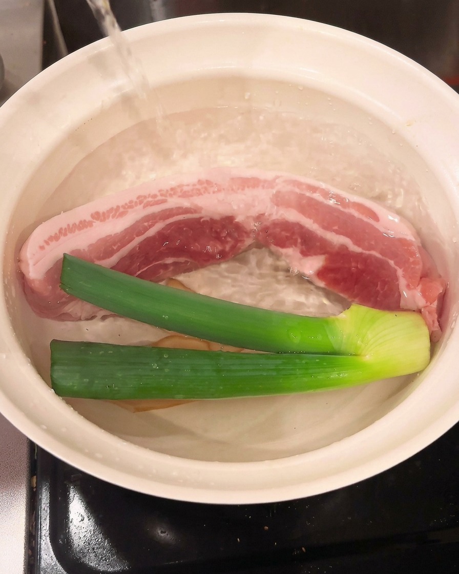 Il vino da cucina viene versato nella pentola, unendosi alla carne e agli aromi.