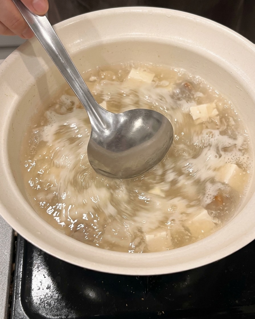 Acqua e sake vengono versati in una pentola pulita utilizzando un misurino.