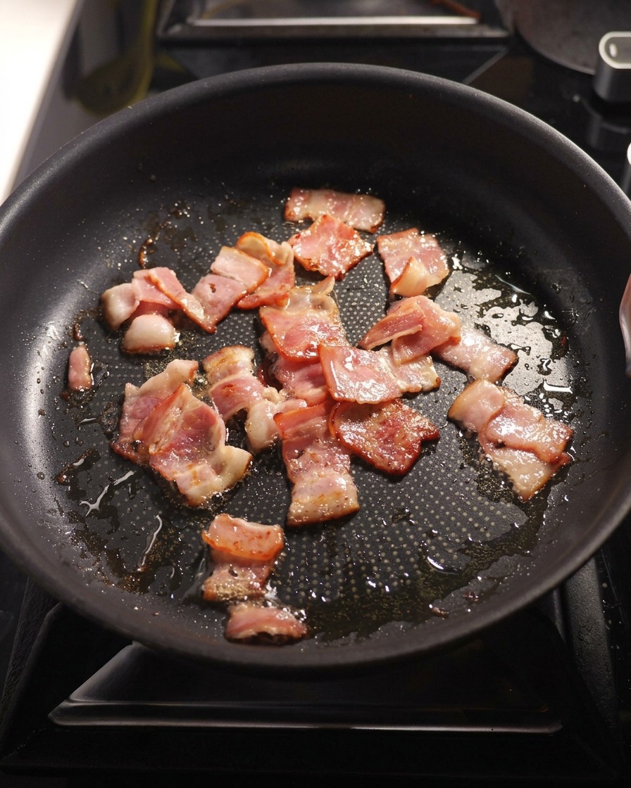Cipolla a cubetti e aglio tritato rosolati in padella con la pancetta croccante.