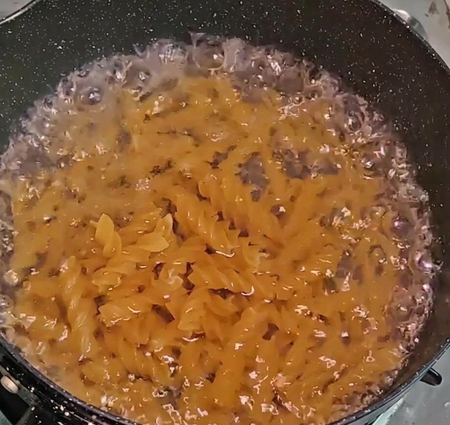 Fusilli che cuociono in una pentola di acqua bollente.