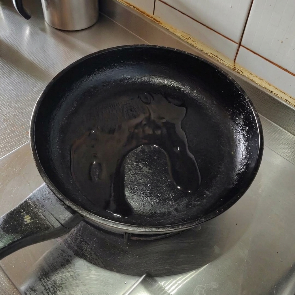 Pezzetti di pancetta che sfrigolano in padella con olio doliva.