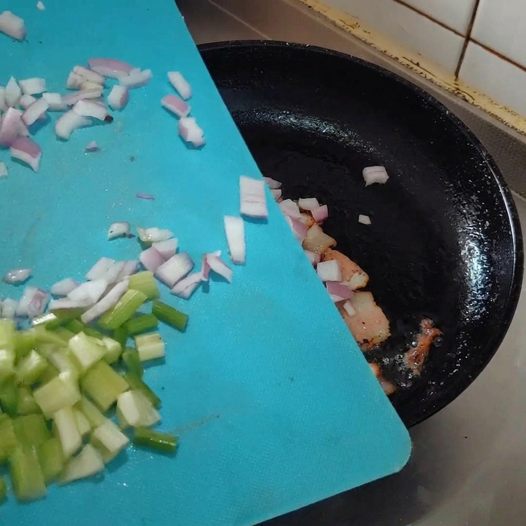 Aglio, scalogno e sedano tritati aggiunti in padella con la pancetta.