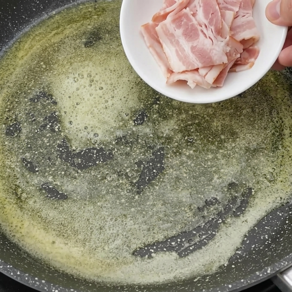Pezzetti di pancetta che rosolano nel burro fuso fino a diventare dorati.