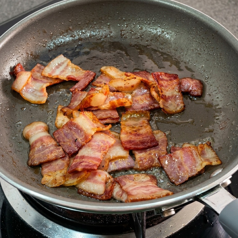 Grasso della pancetta sciolto e pancetta dorata in padella.