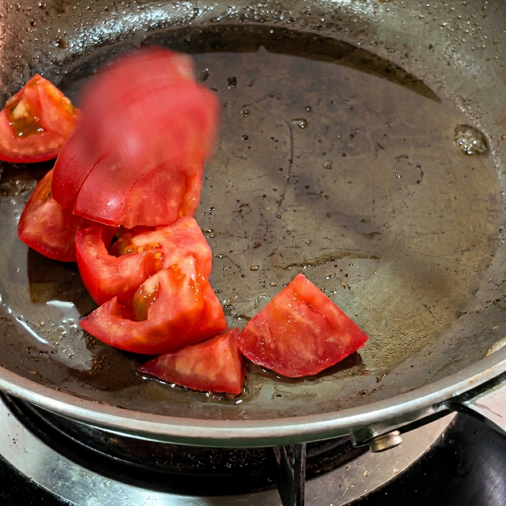 Pezzi di pomodoro che si ammorbidiscono nel grasso di pancetta.