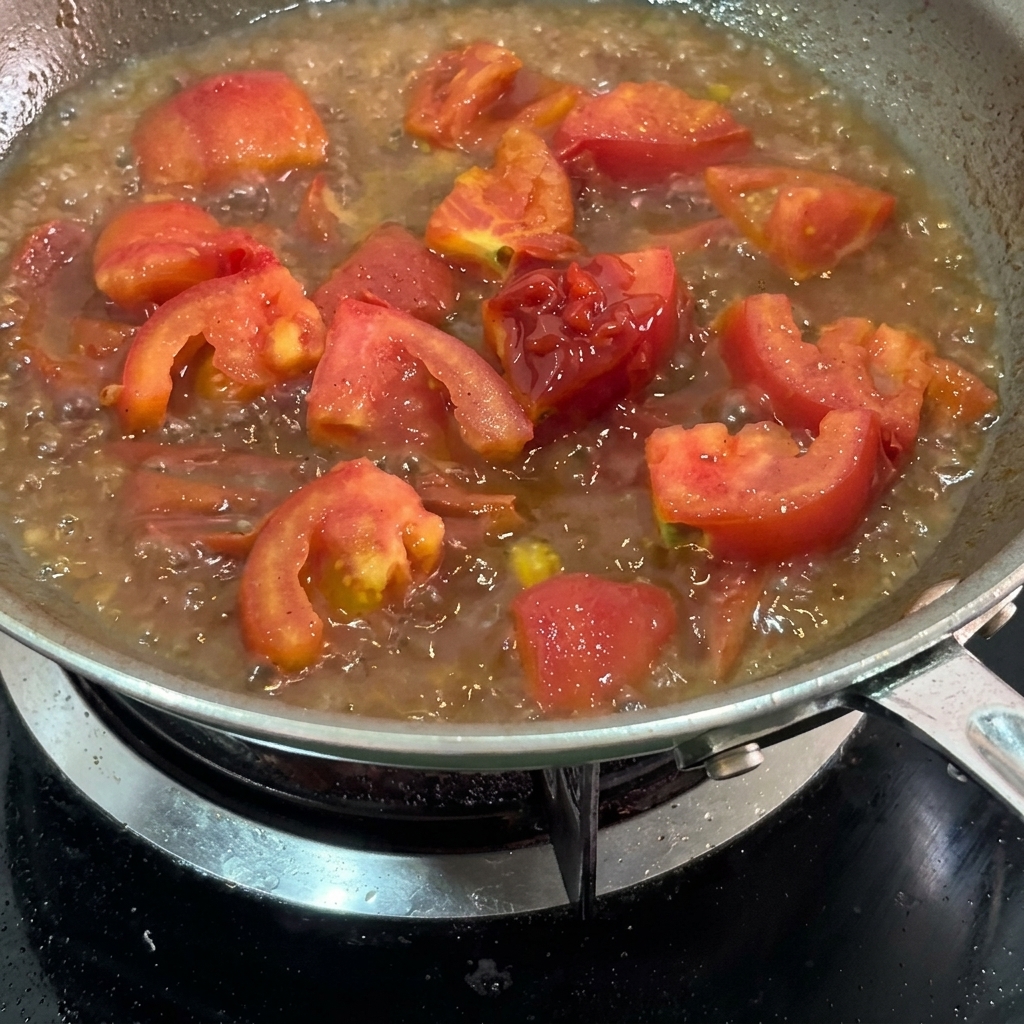 Ketchup aggiunto al composto di pomodoro in cottura.
