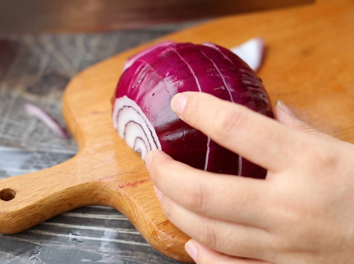 Cipolla rossa tagliata a cubetti piccoli su un tagliere.