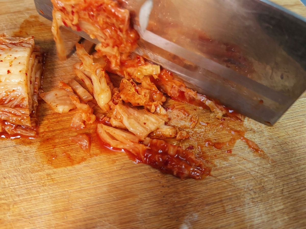 Strisce di kimchi coreano piccante disposte su un tagliere.