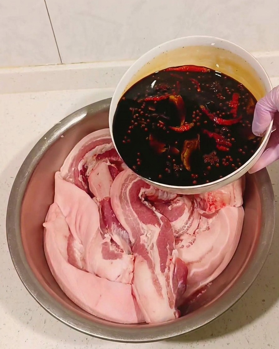 Marinata di soia raffreddata versata sulla pancetta in una ciotola.