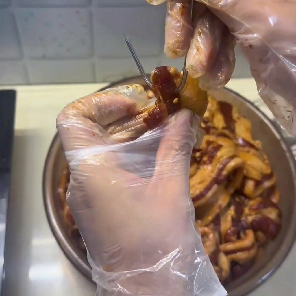 Strisce di pancetta essiccata, ora sode, disposte con cura in un cestello per il vapore.