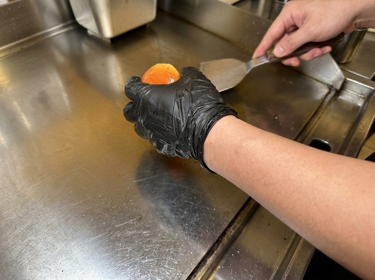 Panini da hamburger imburrati che tostano su una piastra calda fino a diventare dorati e croccanti.